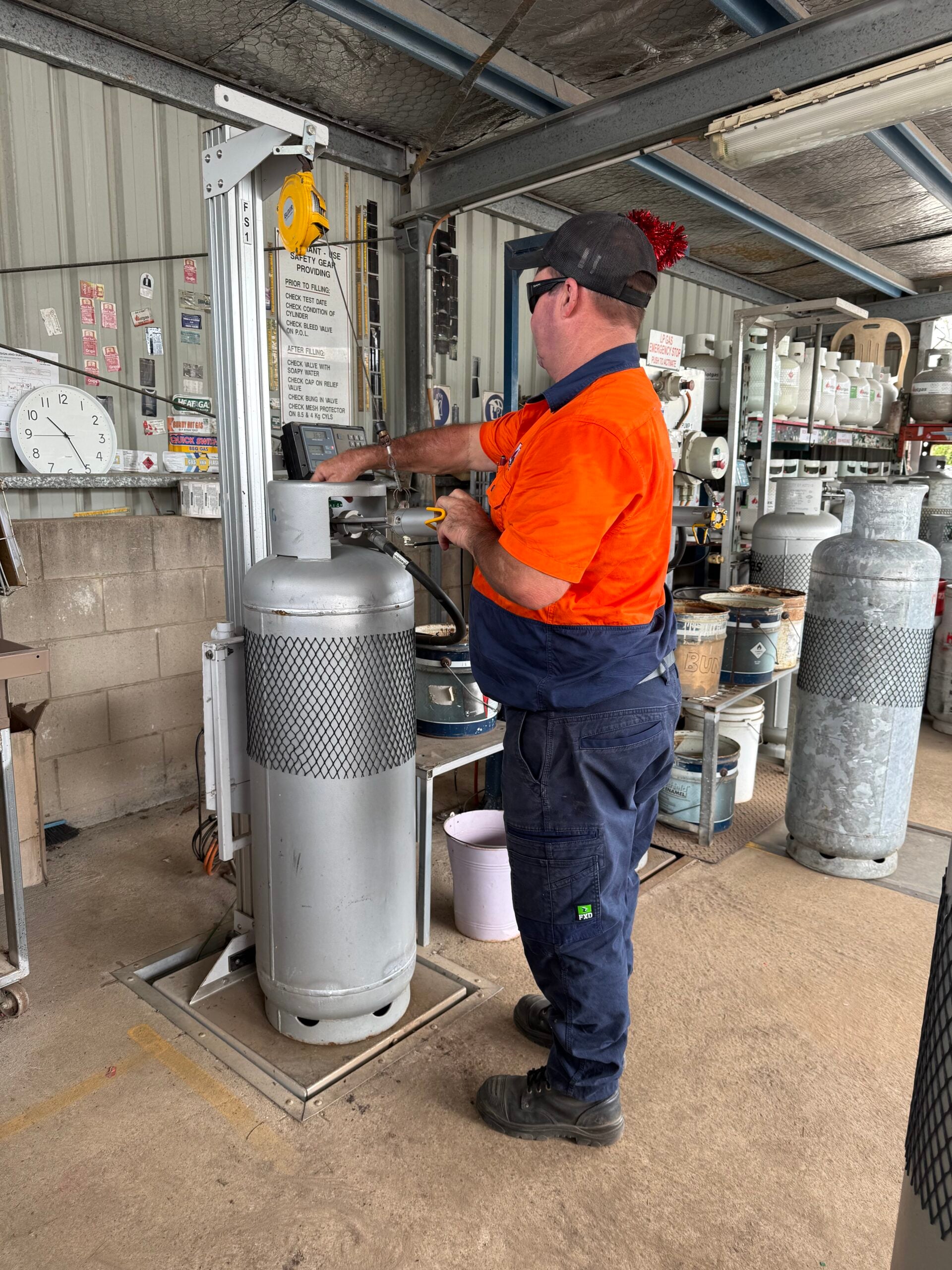 Team member filling LPG cylinder at digital scales